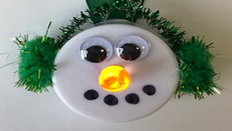 tea light candle decorated as a snowman face